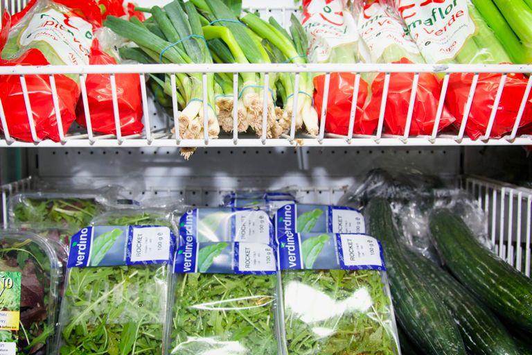 Leafy greens presented on supermarket produce shelving.